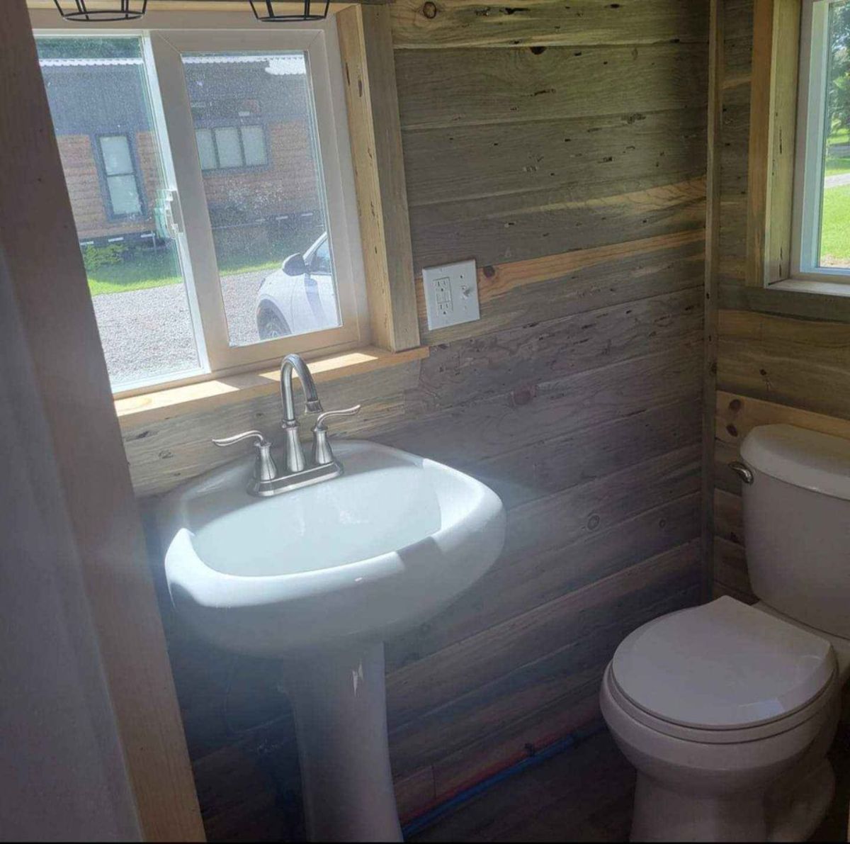 Standard toilet and sink in bathroom of 20’ tiny house with two lofts