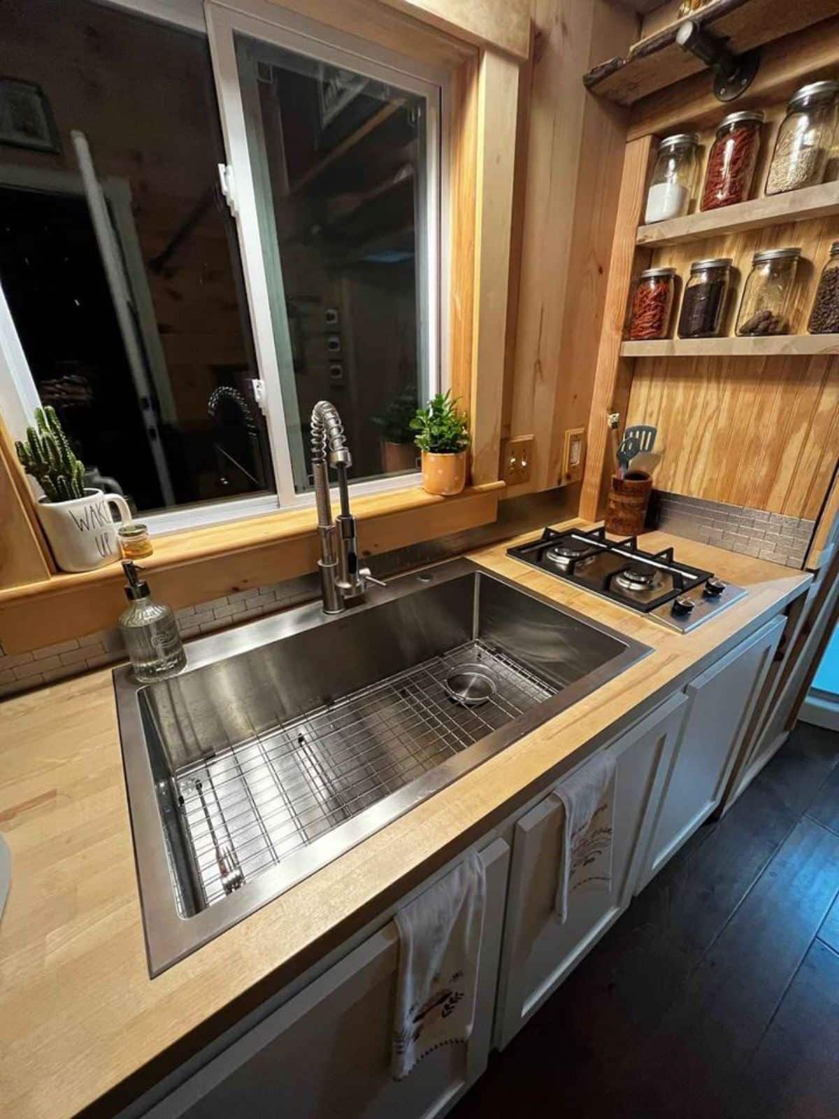 Propane gas burner, sink with storage and other shelves in kitchen