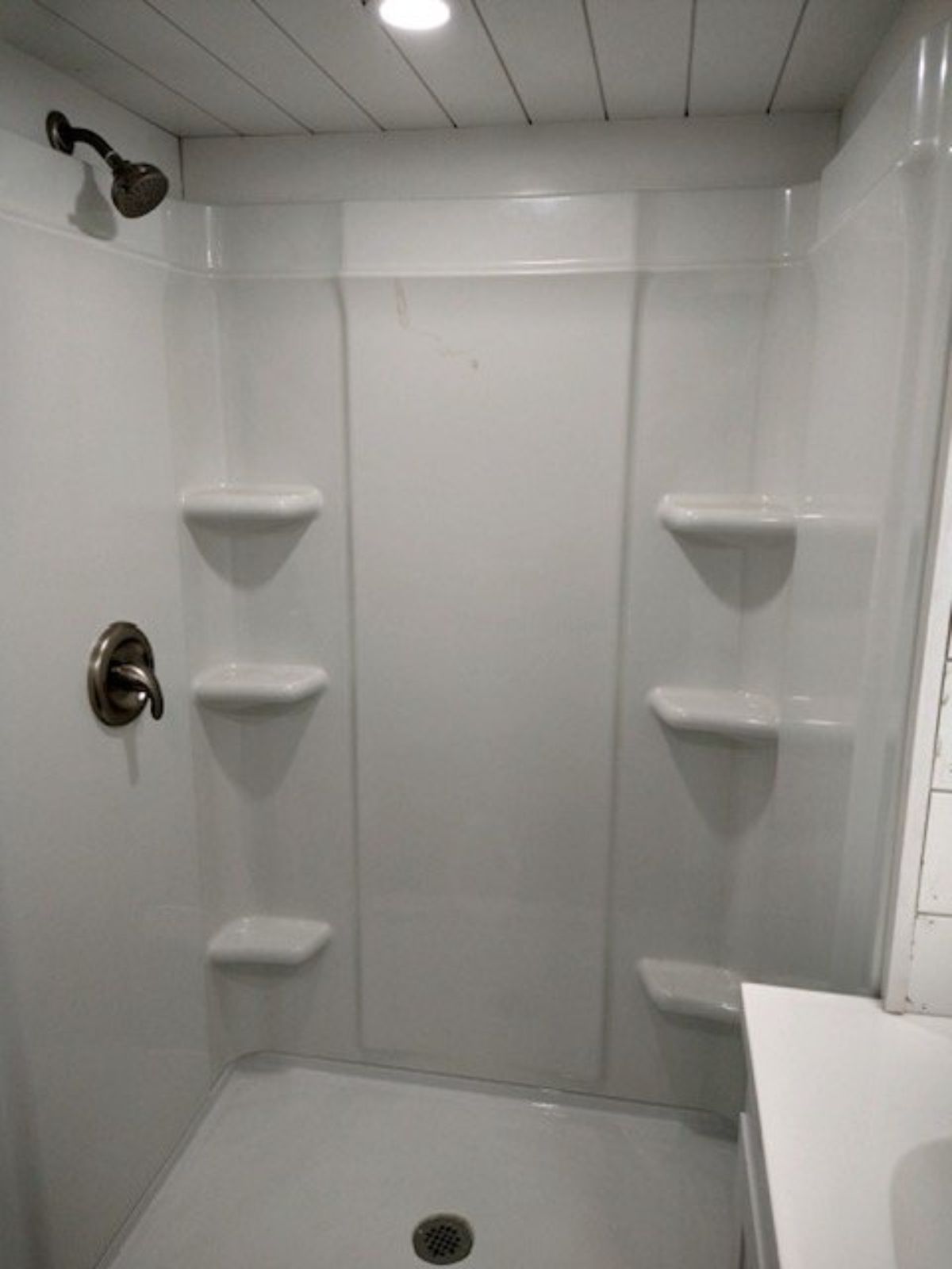 Long fiberglass shower space in bathroom