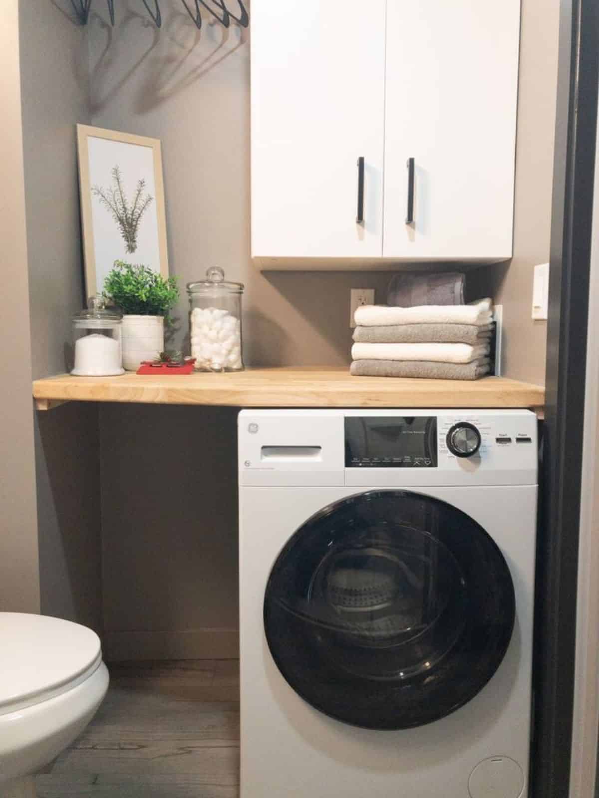 Washer dryer combo with tankless hot water is also installed in bathroom of Luxurious & Stunning Tiny Home