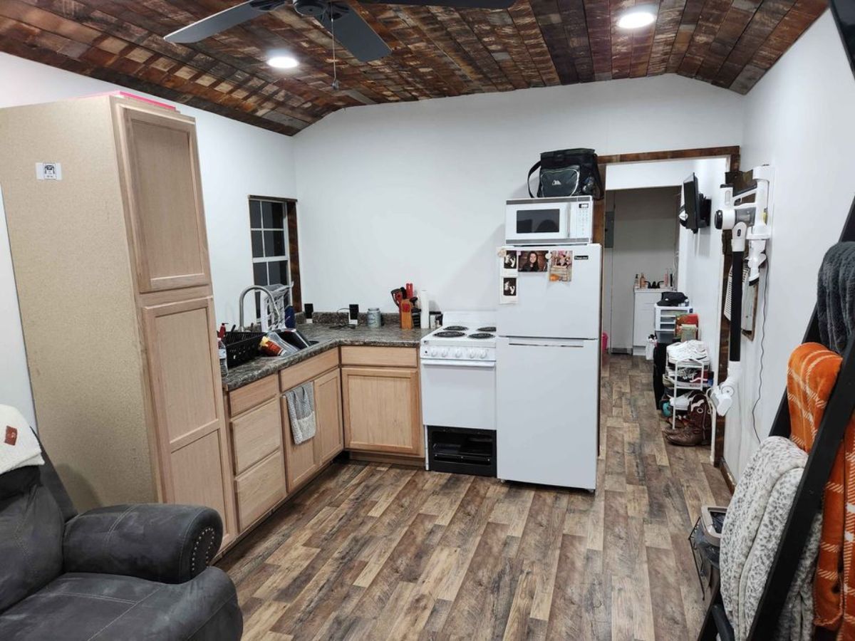 L shaped kitchenette of tiny home with downstairs bedroom