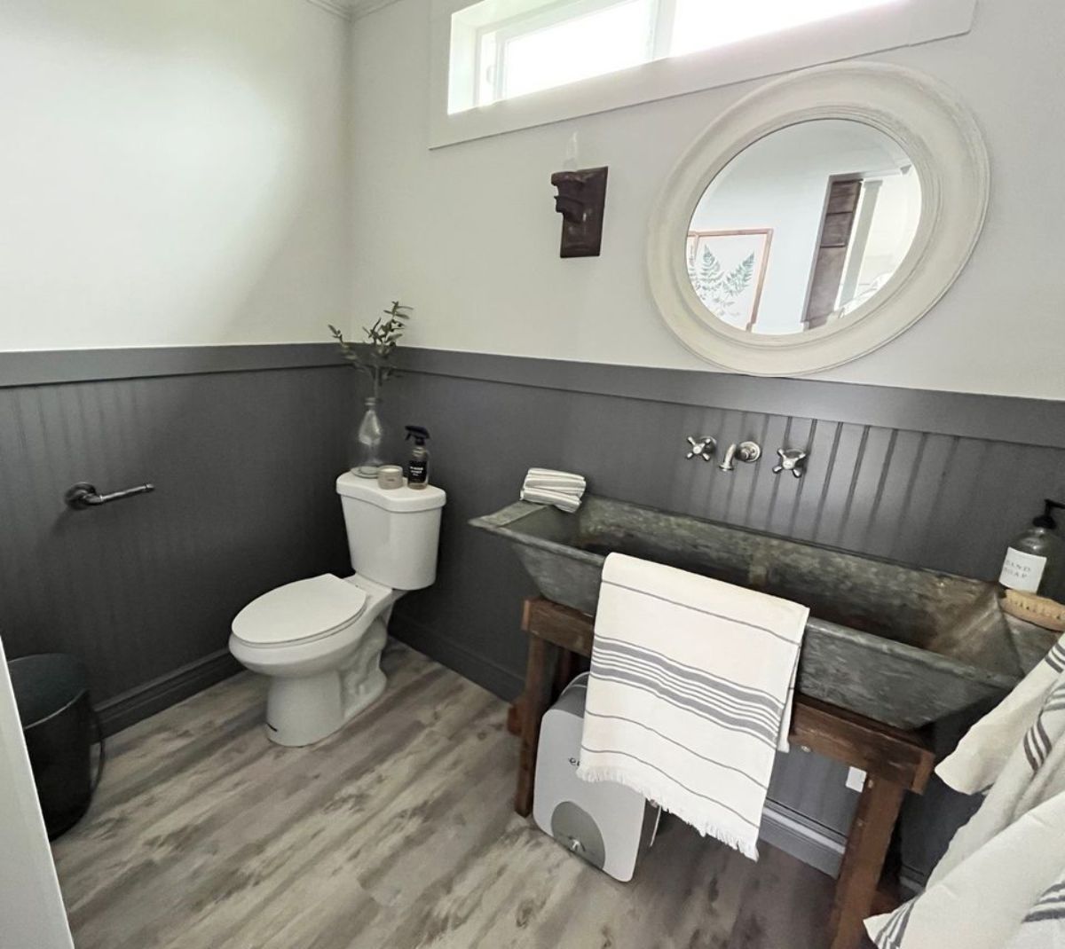 Standard toilet with huge sink and mirror in bathroom of tiny cabin home