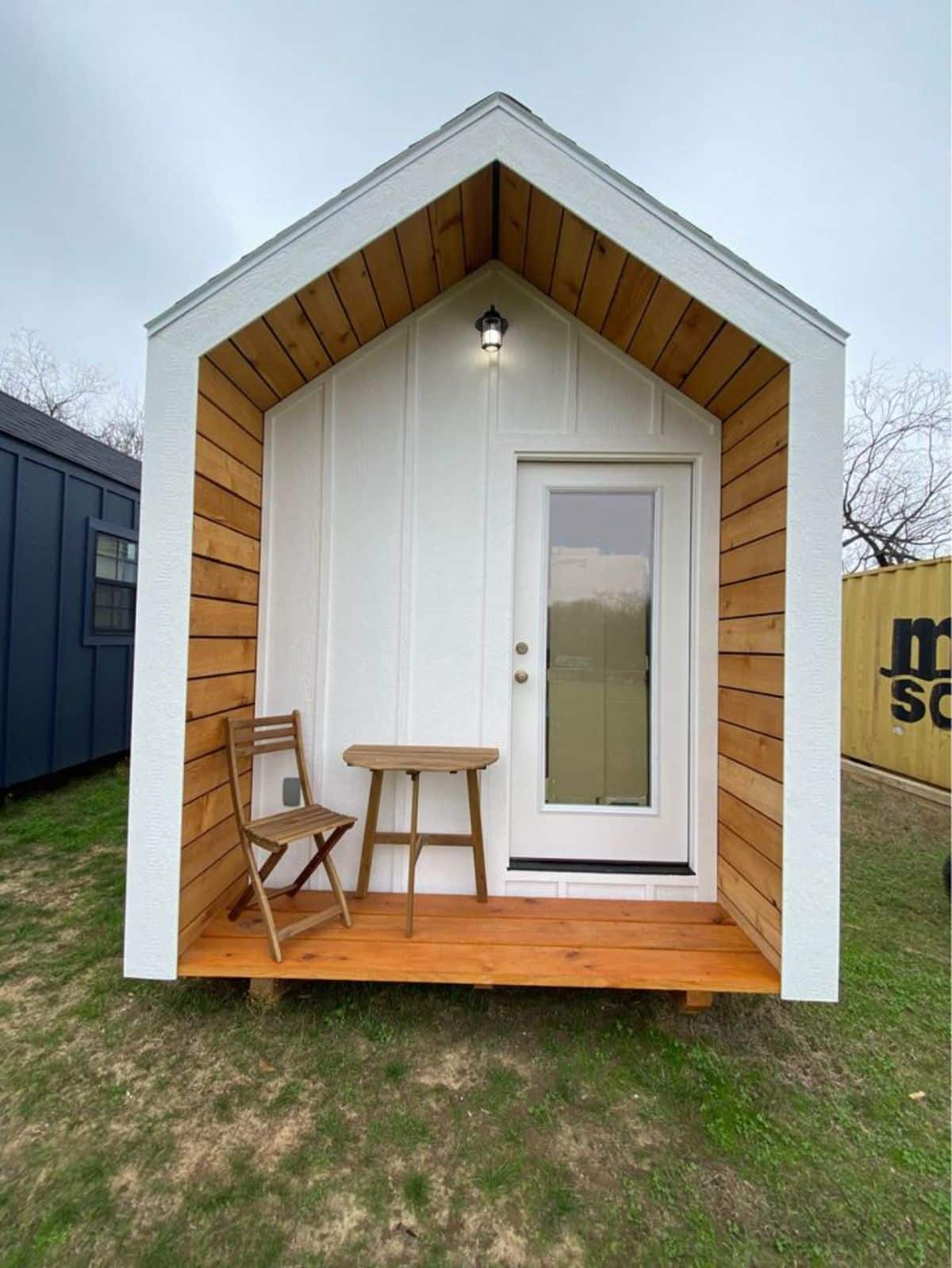 Main entrance view of Affordable Tiny Home with small table and chair on the porch
