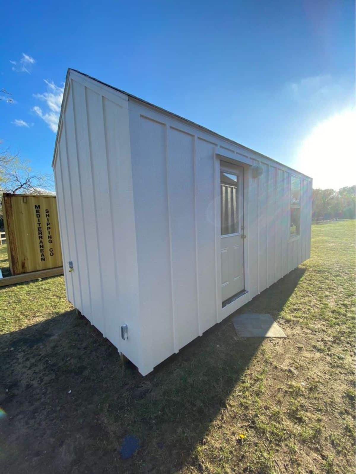 Backside view of white exterior of Affordable Tiny Home