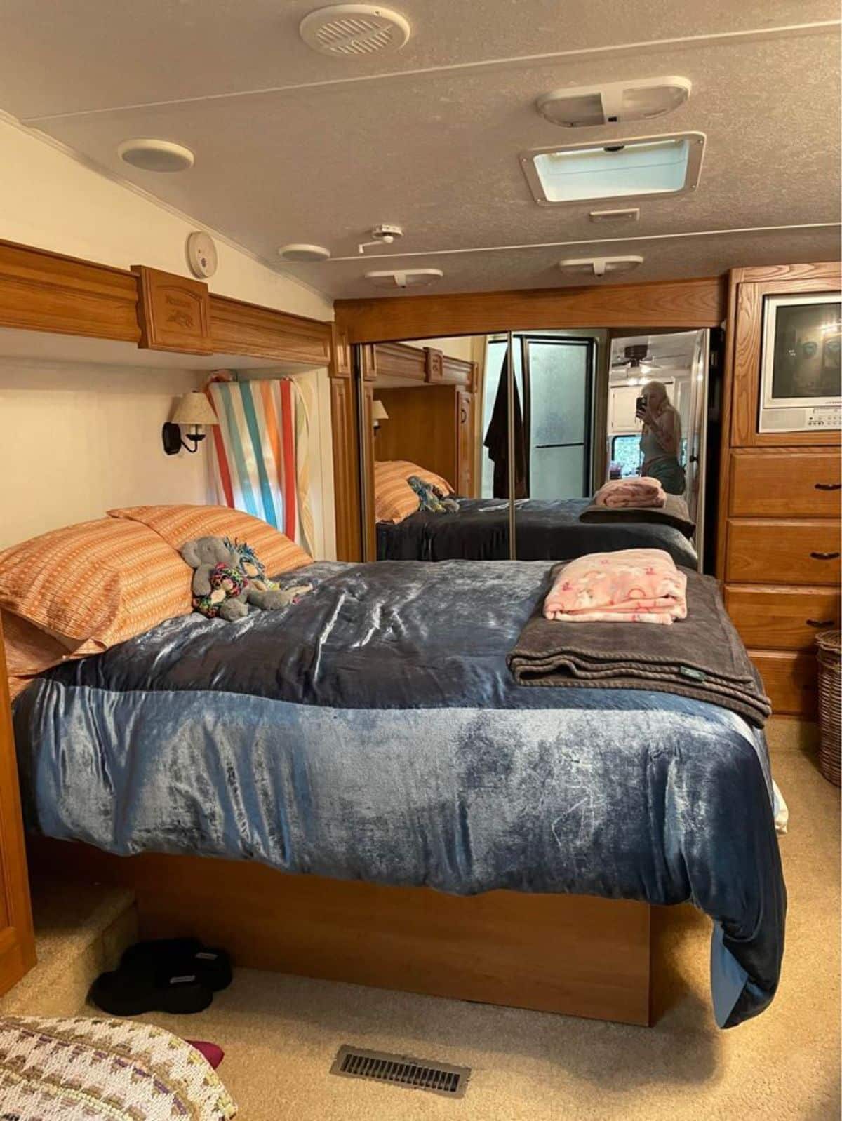 Queen size bed with closet, television set in bedroom of Camper Tiny Home