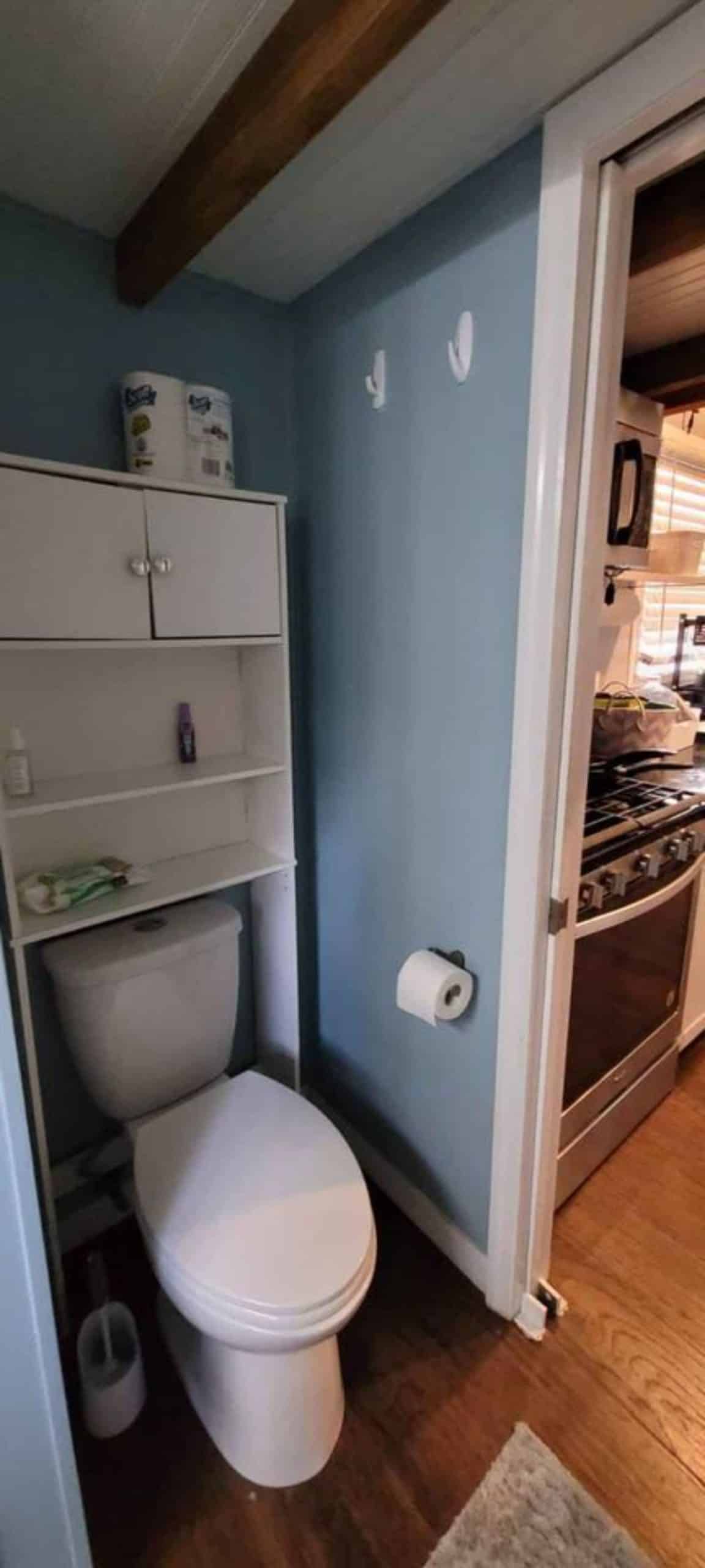 Open shelves above the toilet of 1 bedroom tiny home