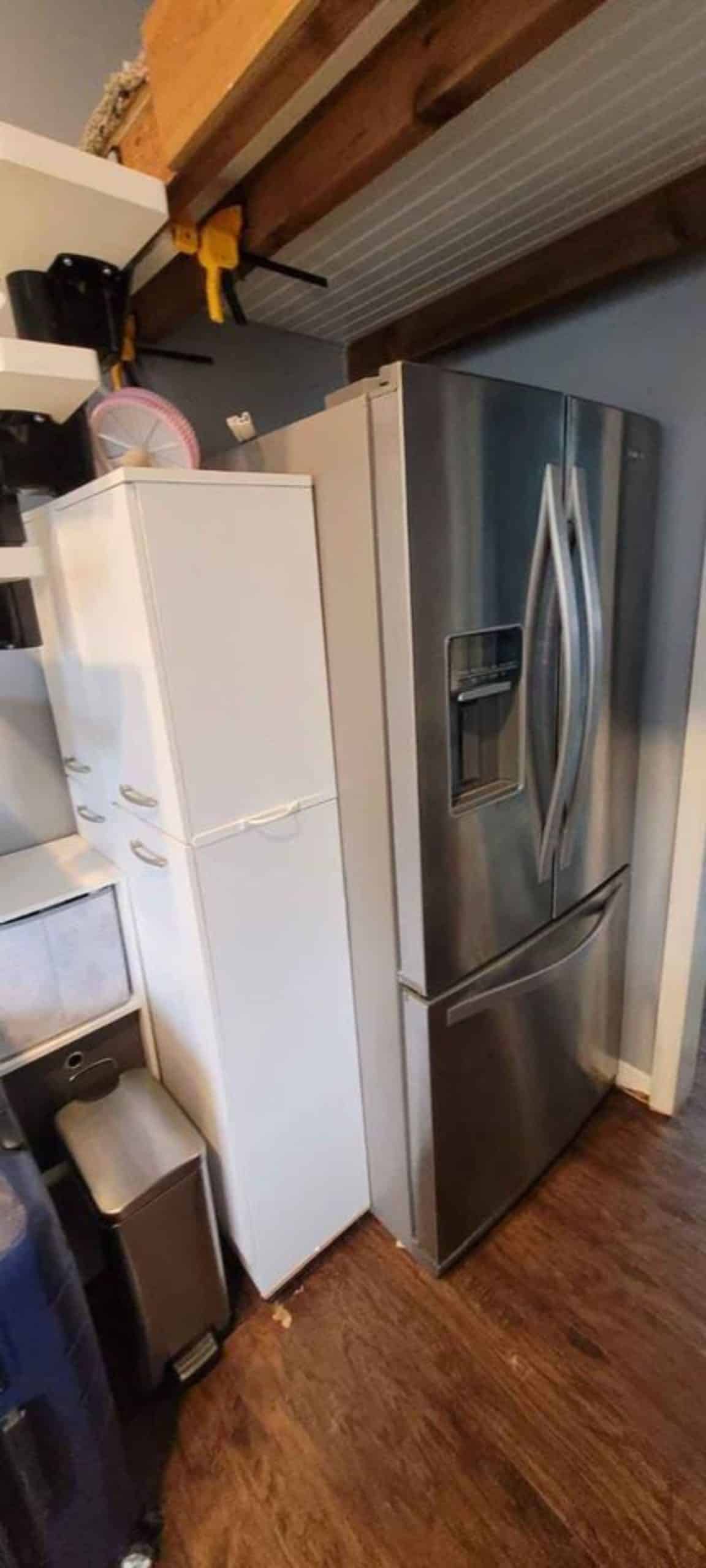Refrigerator in kitchen area of 1 bedroom tiny home