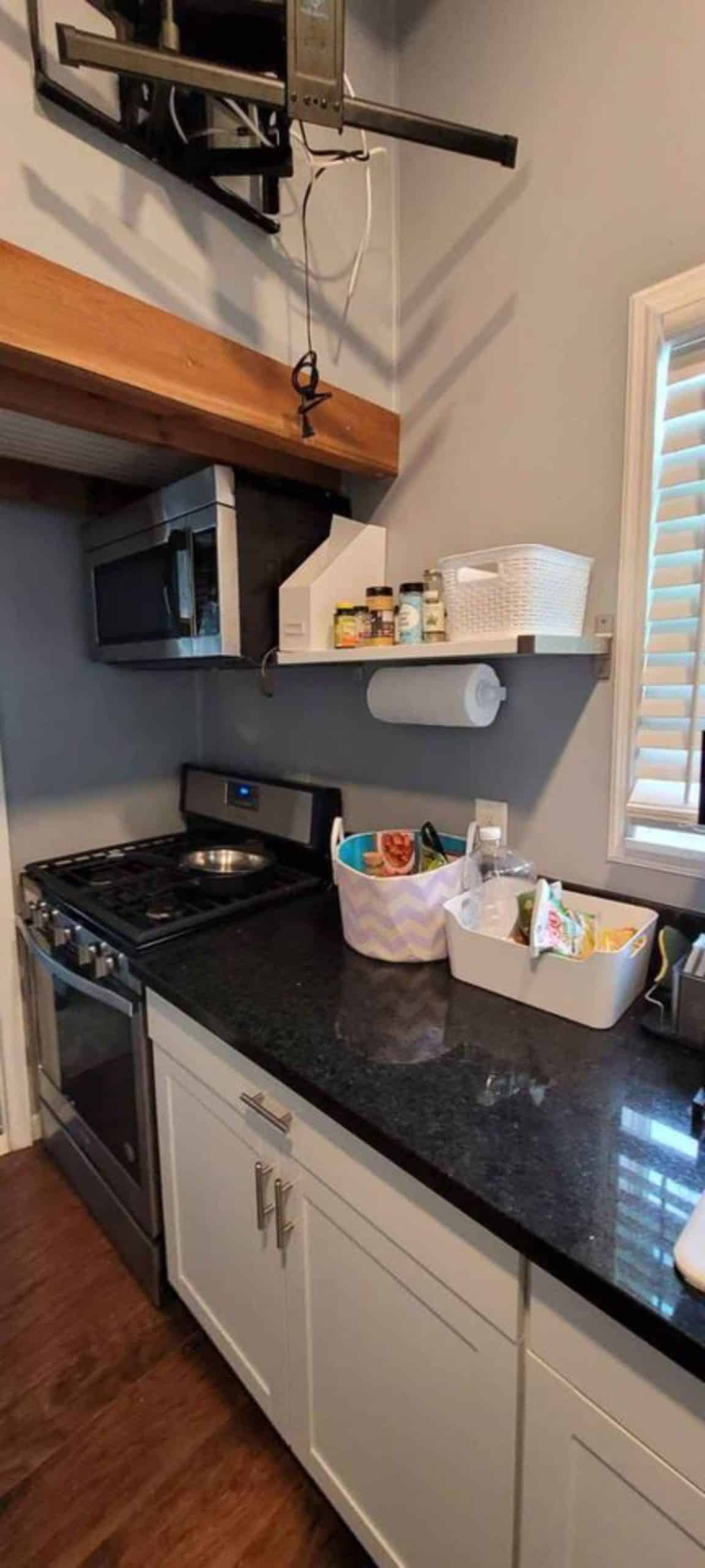 Kitchen area with alll the essential appliances of 1 bedroom tiny home