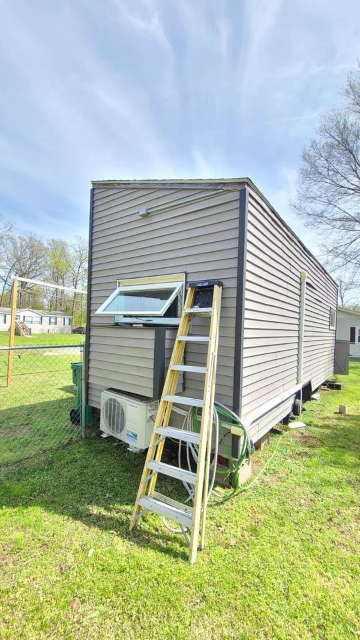 ladder propped on back of tiny home
