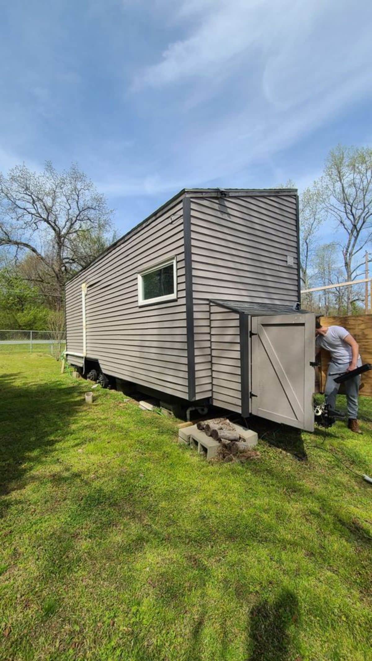 beige siding on tiny house on green grass lot