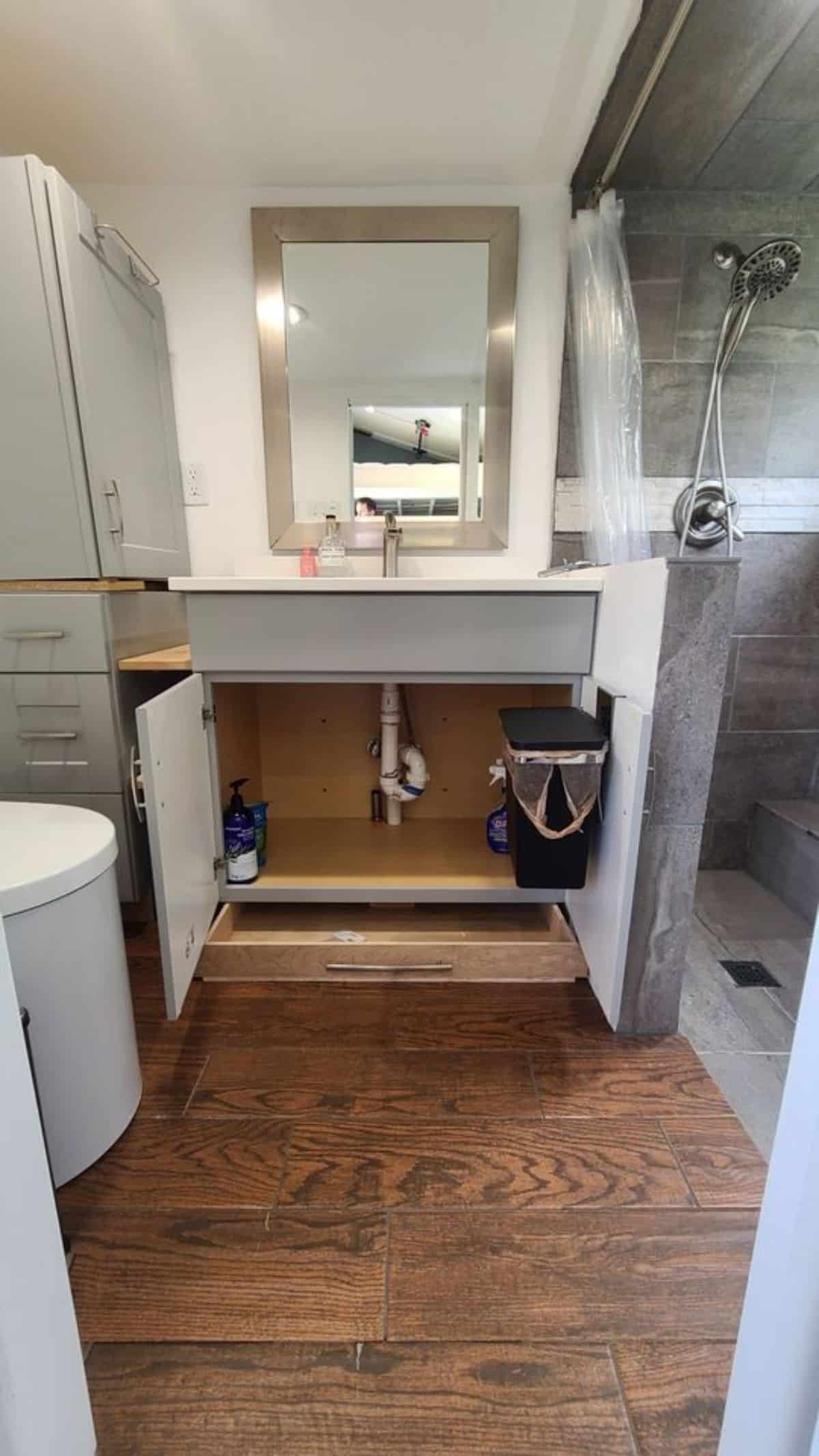 open doors on cabinet underneath bathroom sink