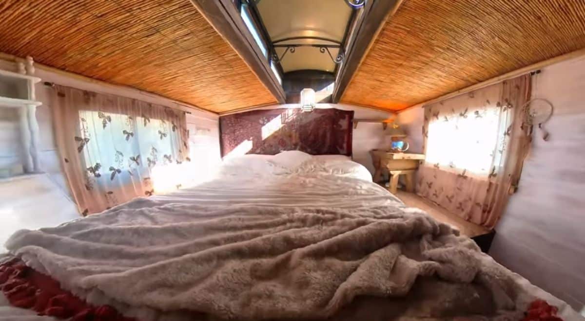 bed in loft with red headboard and carriage roof