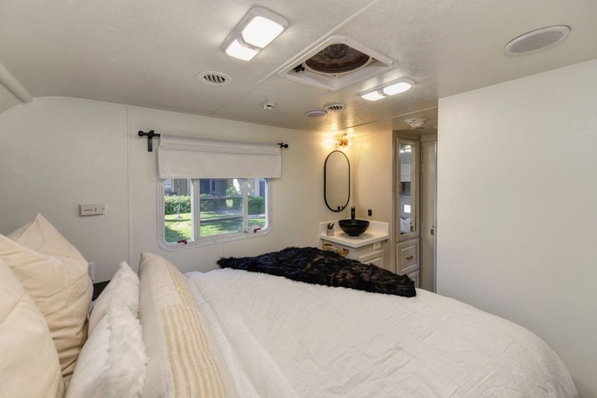 Window besides the bed and Carrier ducted AC system and a thermostat controlled bedroom fan