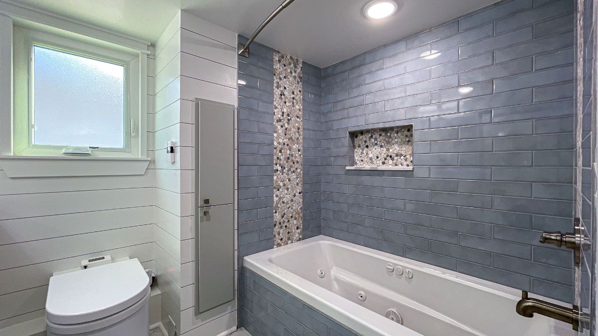 blue gray tile wall above and beside white bathtub