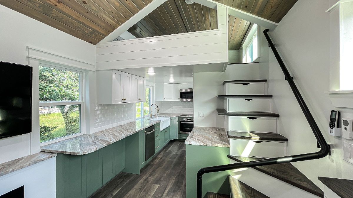 white stairs with light green cabinets inside tiny home