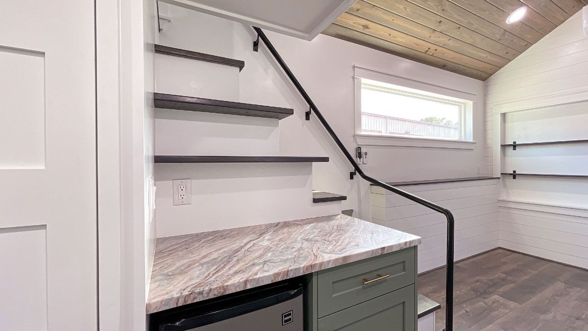 stairs to loft behind cabinet with dishwasher