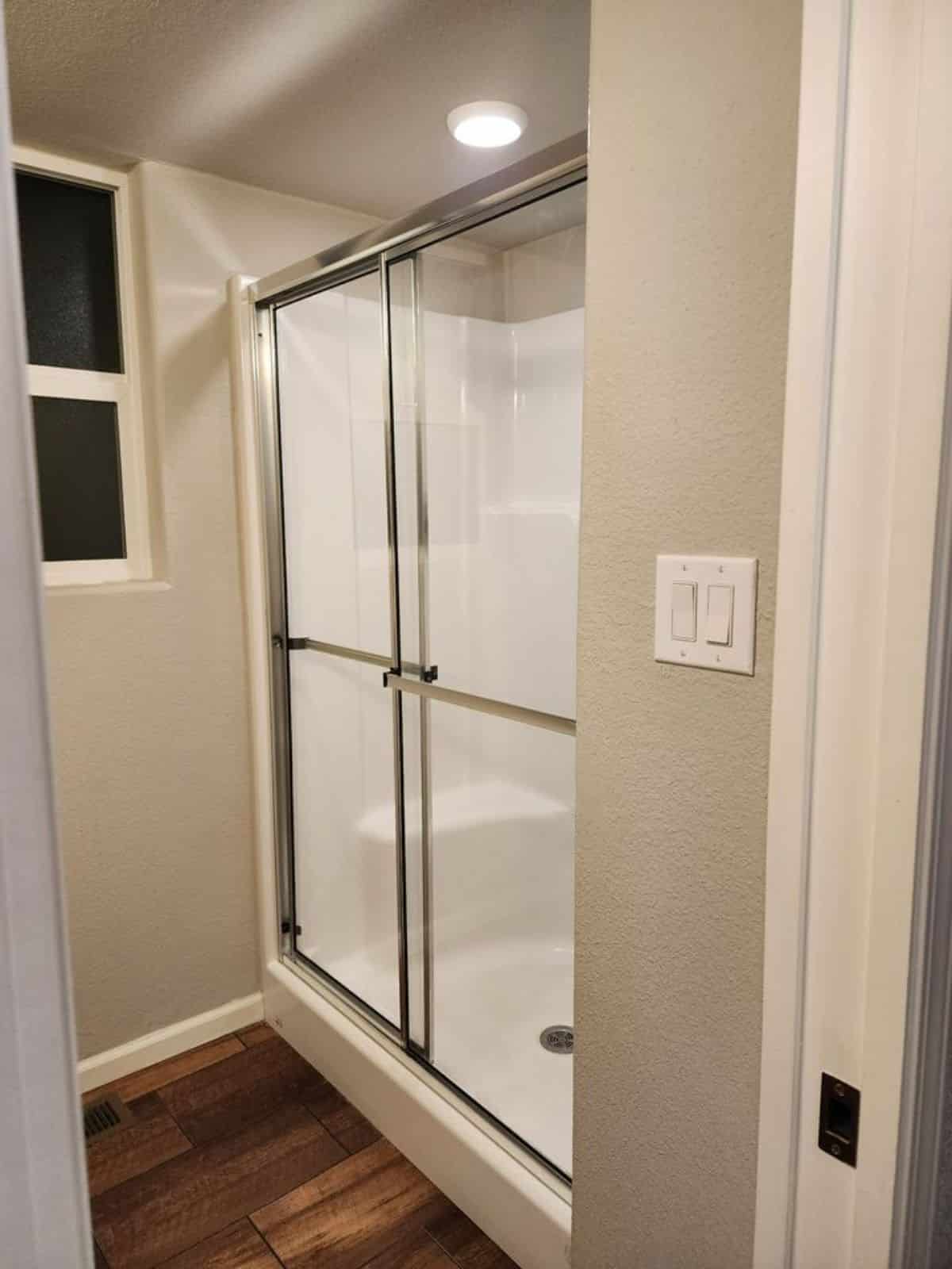 Glass shower enclosure in bathroom of Spacious Tiny House