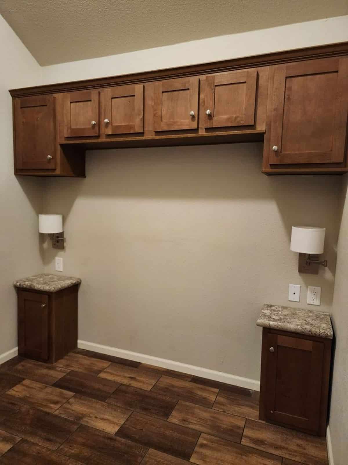 Storage cabinets in bedroom with 2 side tables with lamp and open space for queen bed in bedroom of Spacious Tiny House