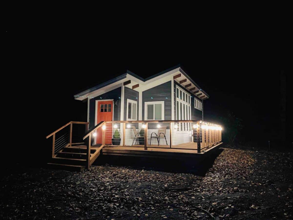 tiny house after dark with lights on porch