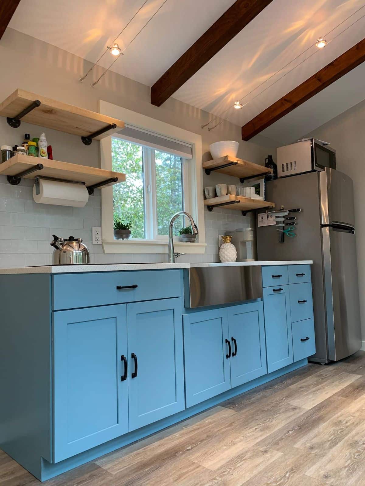 open shelves above blue cabinets in kitchen