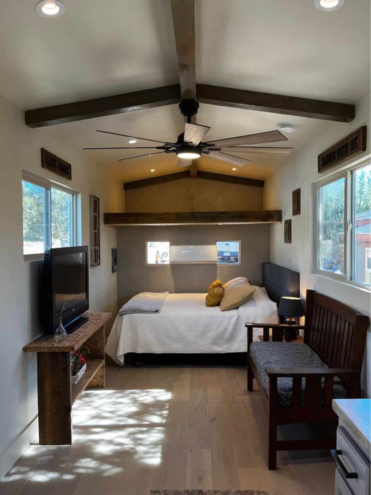 Open bedroom area of newly constructed 30’ tiny home has a huge fan and air condition unit