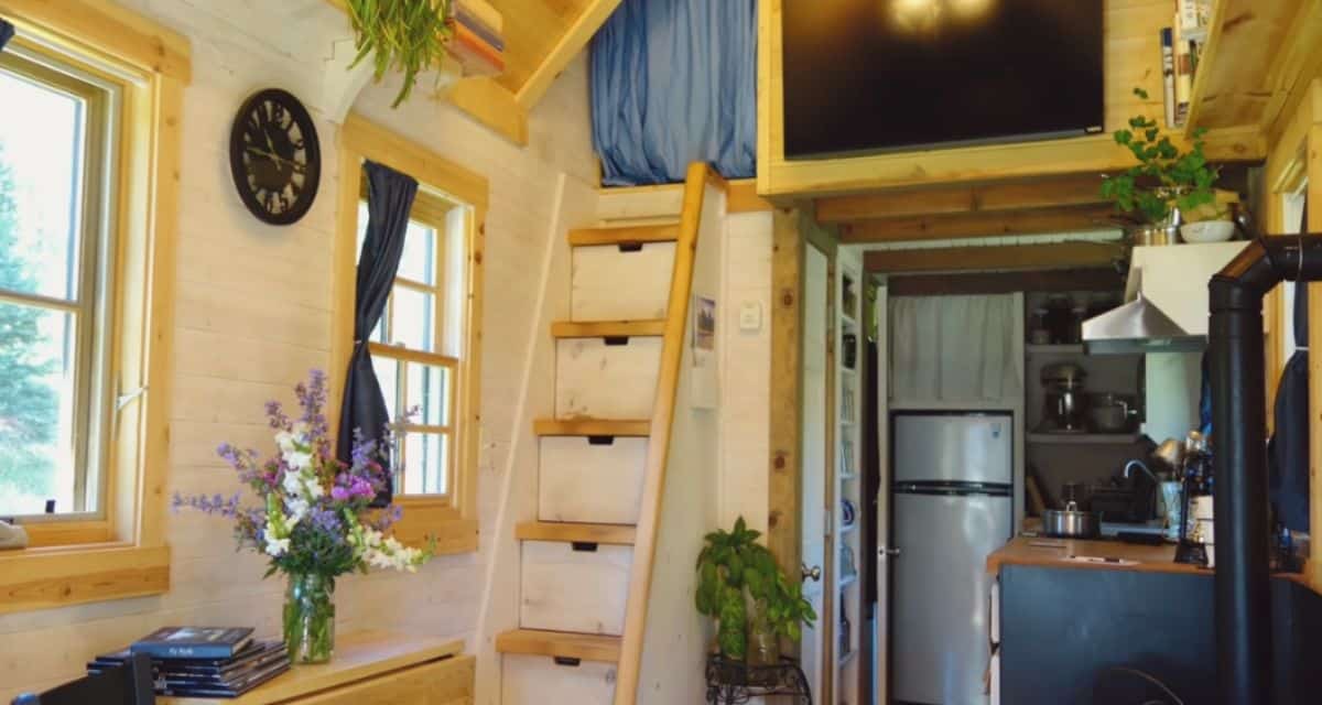 wood ladder leading to loft with blue curtain