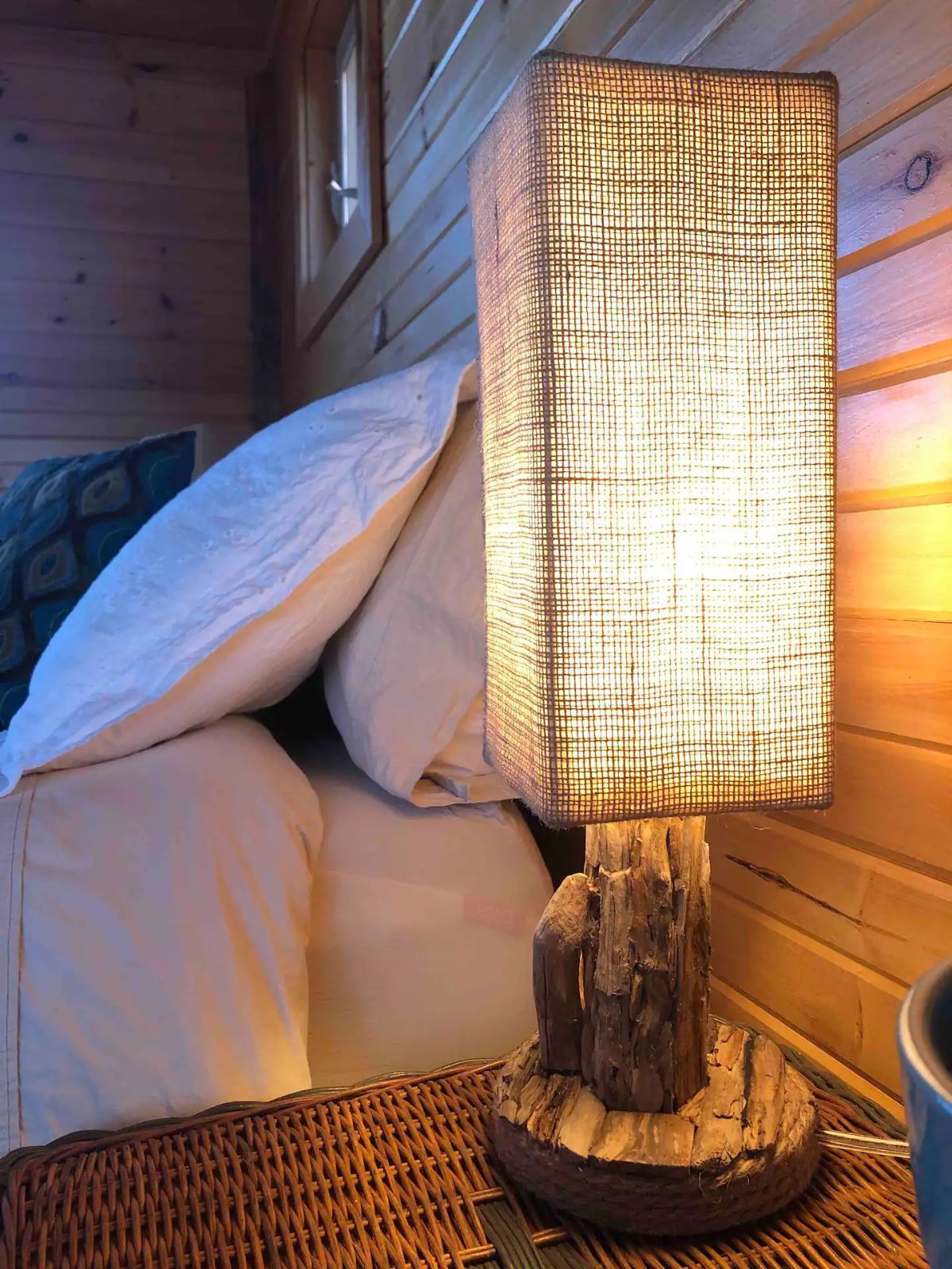 tall rectangle lamp against wall by bed