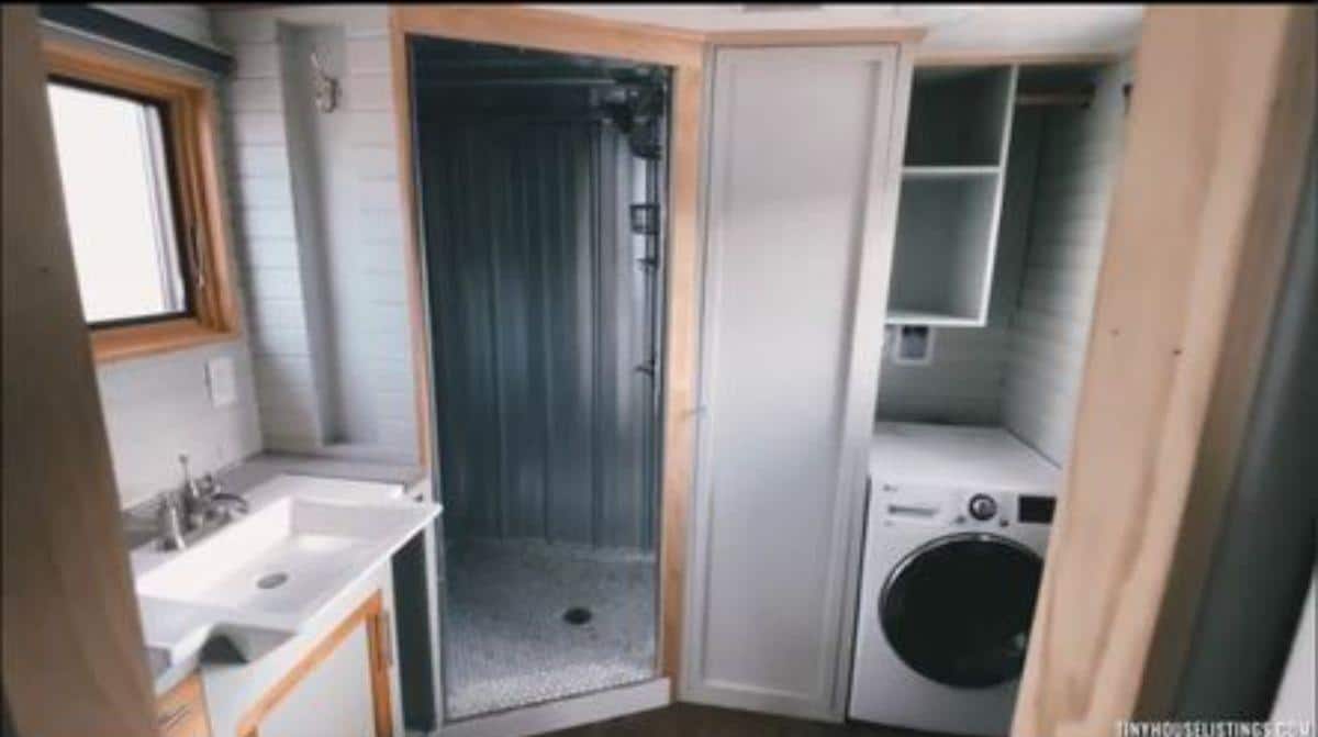 Separate shower area and washer dryer combo in bathroom