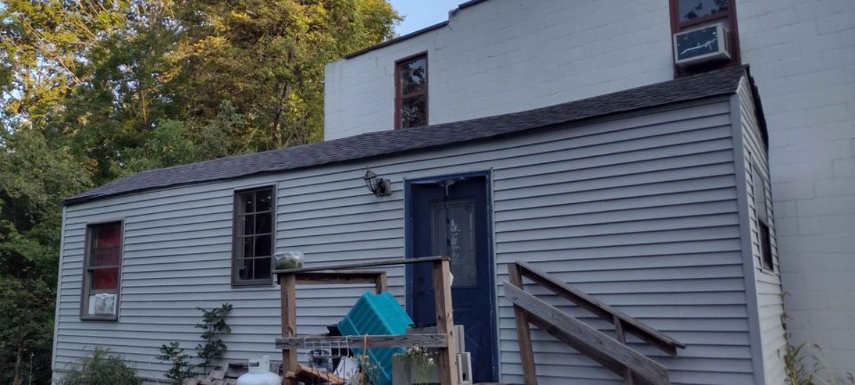 Dark blue door of Rustic tiny home makes it look more rustic
