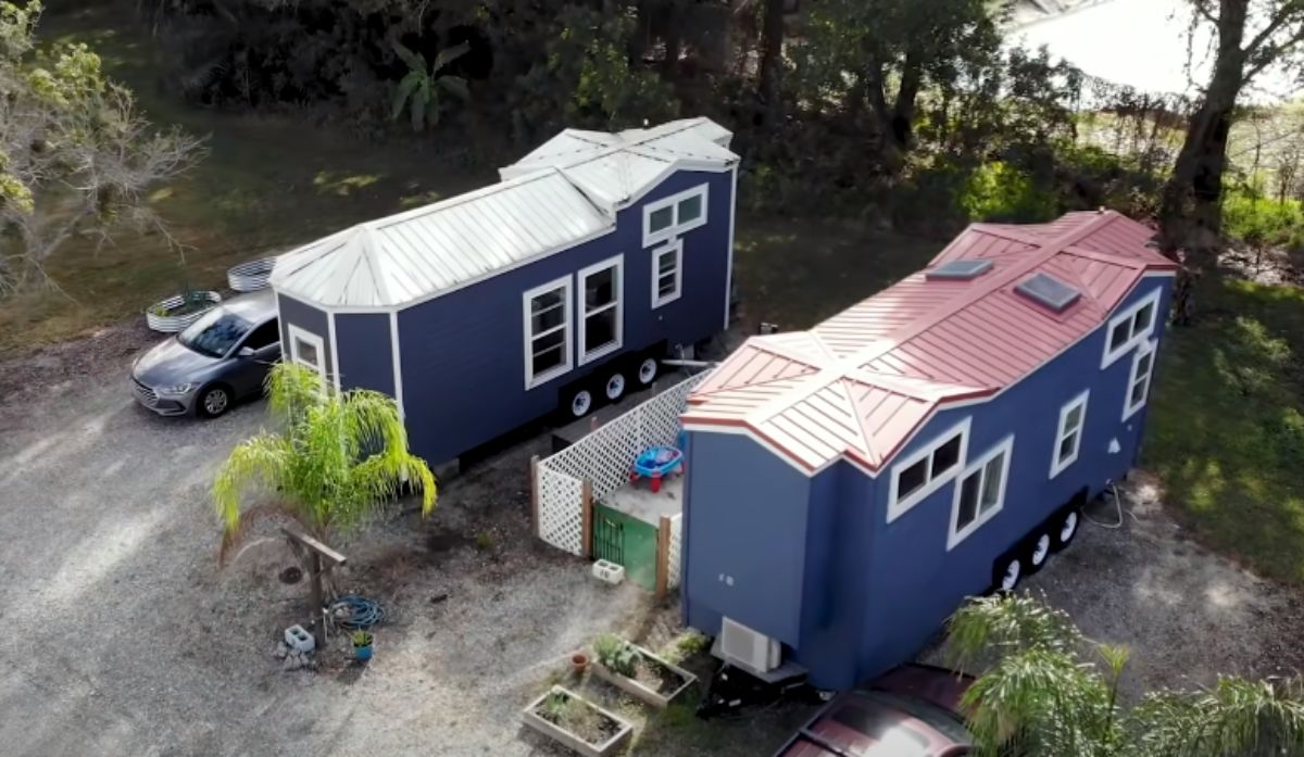 two blue tiny houses side by side with gravel driveway