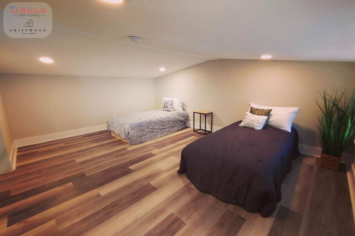 Loft 1 of spacious tiny house has 2 beds  has an ample space left