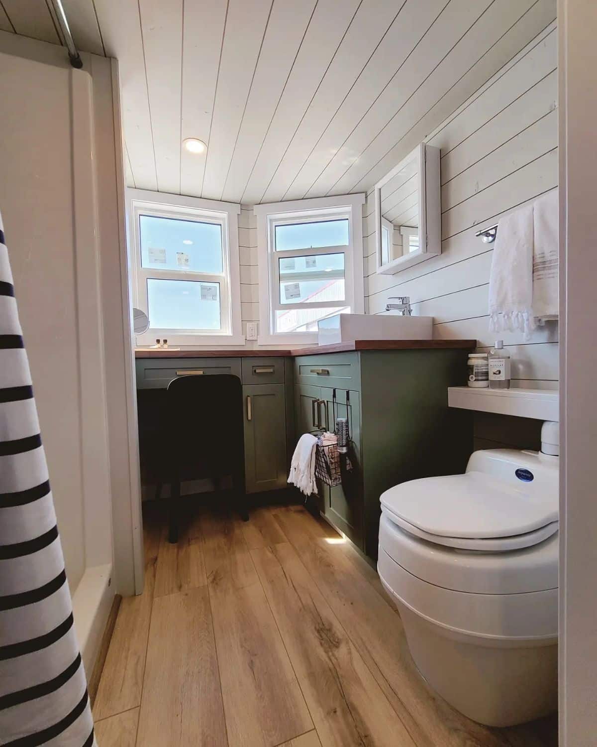 Bathroom area has a standard toilet, sink with vanity and separate shower
