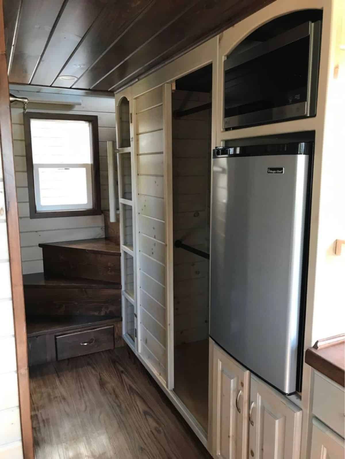Storage cabinets under stairs has refrigerator underneath