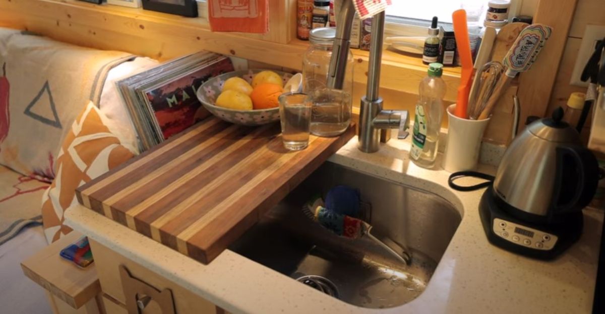 stainless steel sink with cutting board over one side