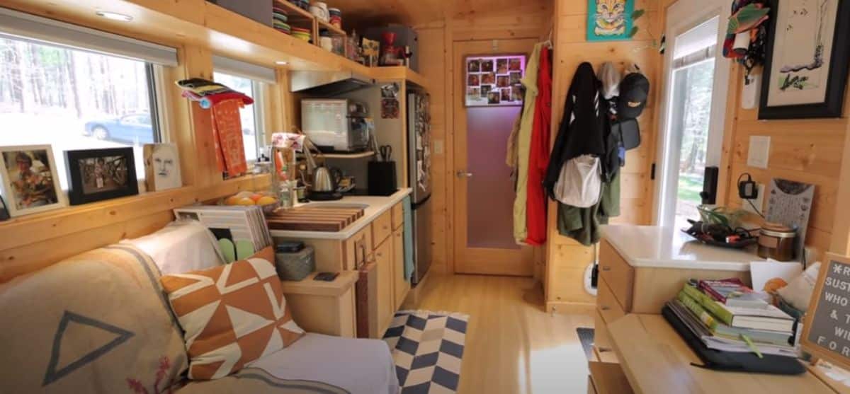 bench seat with quilts on left inside tiny home