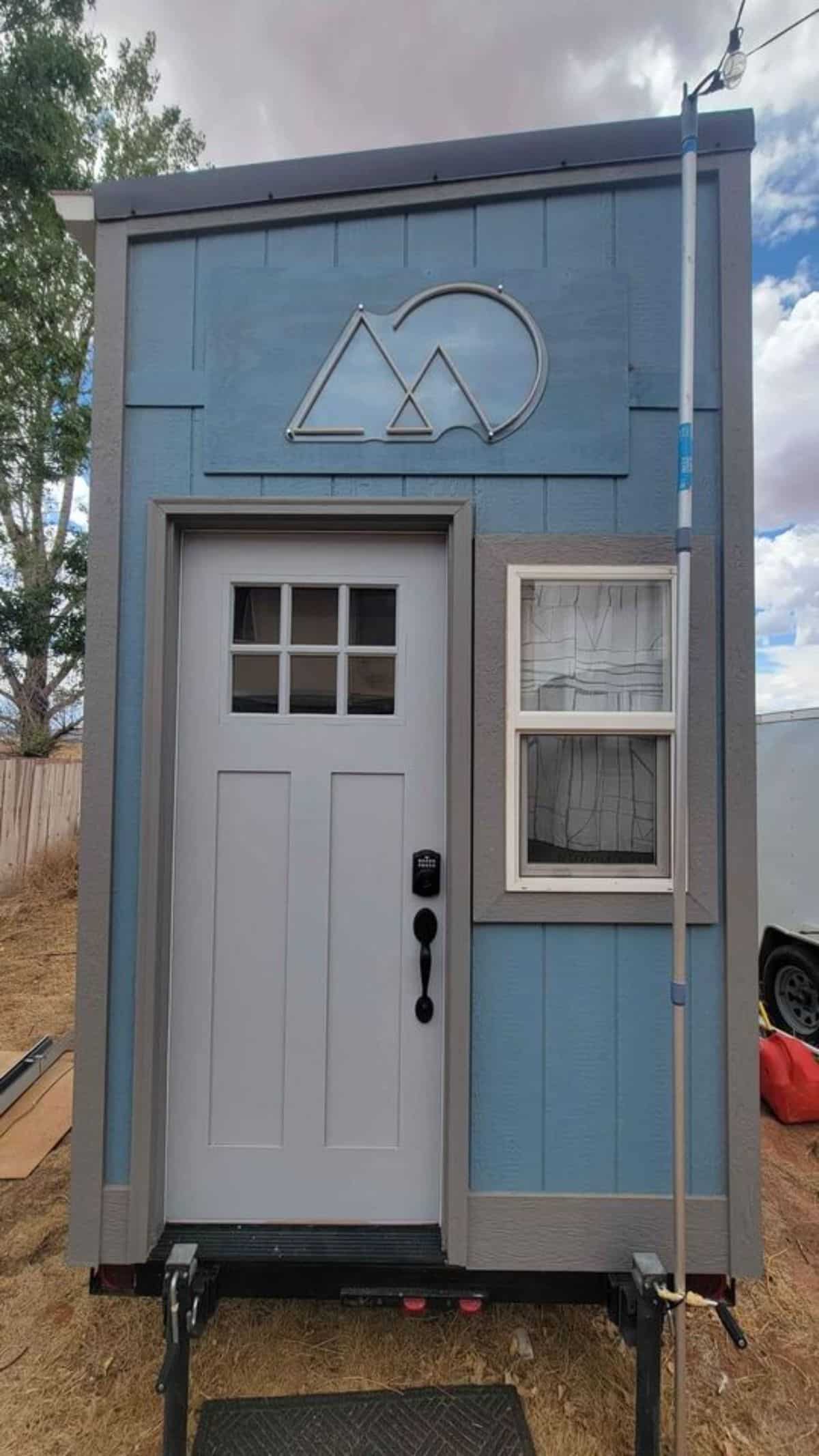 Main door of 14’ compact tiny house from outside with hook to carry with trailer