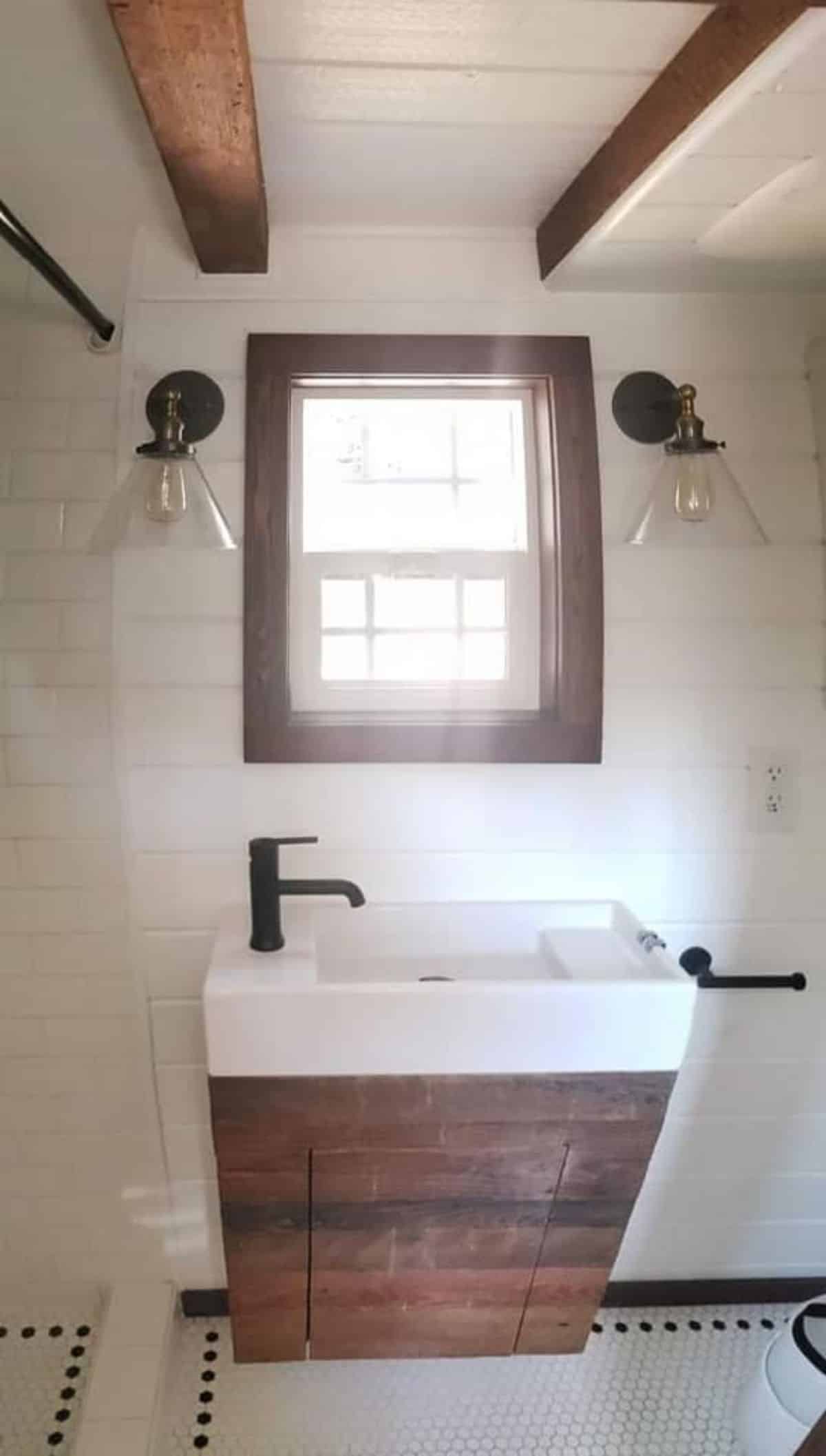 Sink with vanity and window in bathroom of tiny house with two lofts