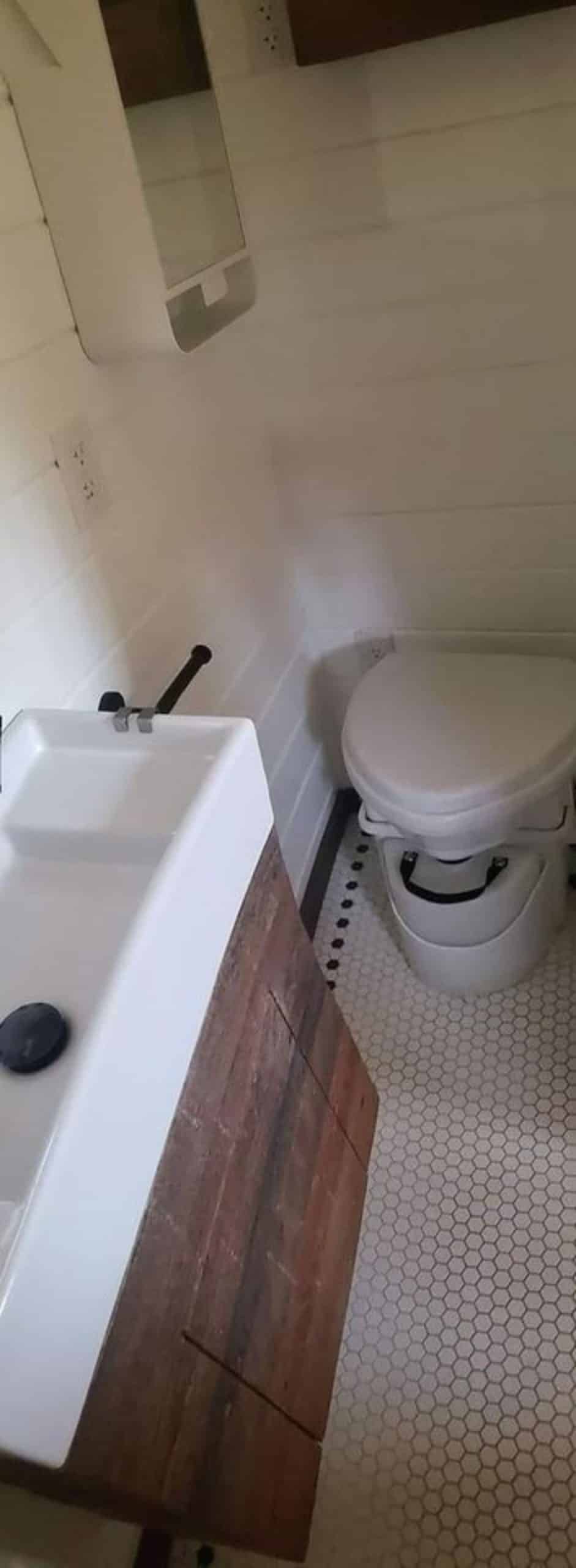 Composting toilet in bathroom of tiny house with two lofts