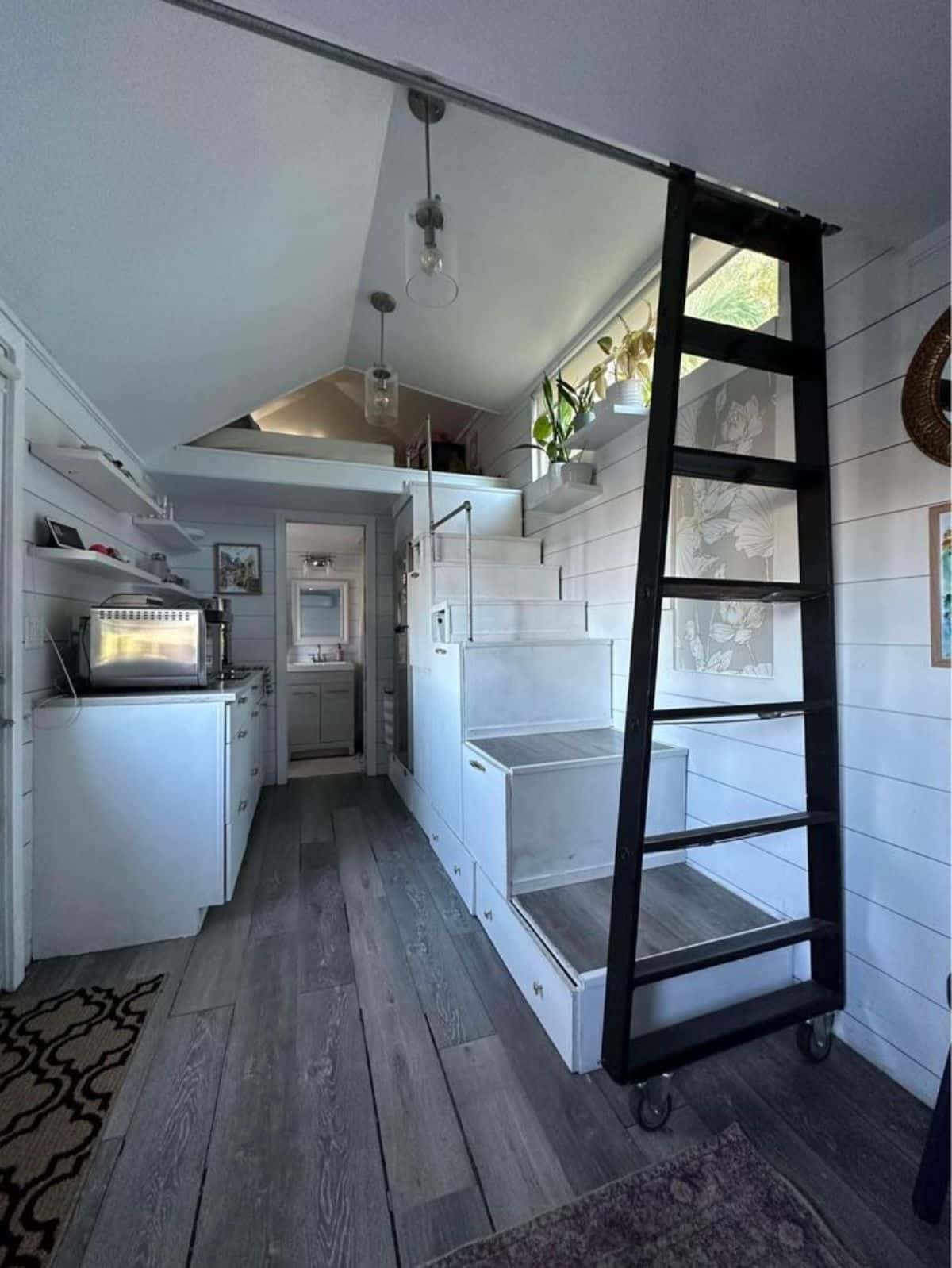 Kitchen, multipurpose stairs and loft view of tiny home with two lofts
