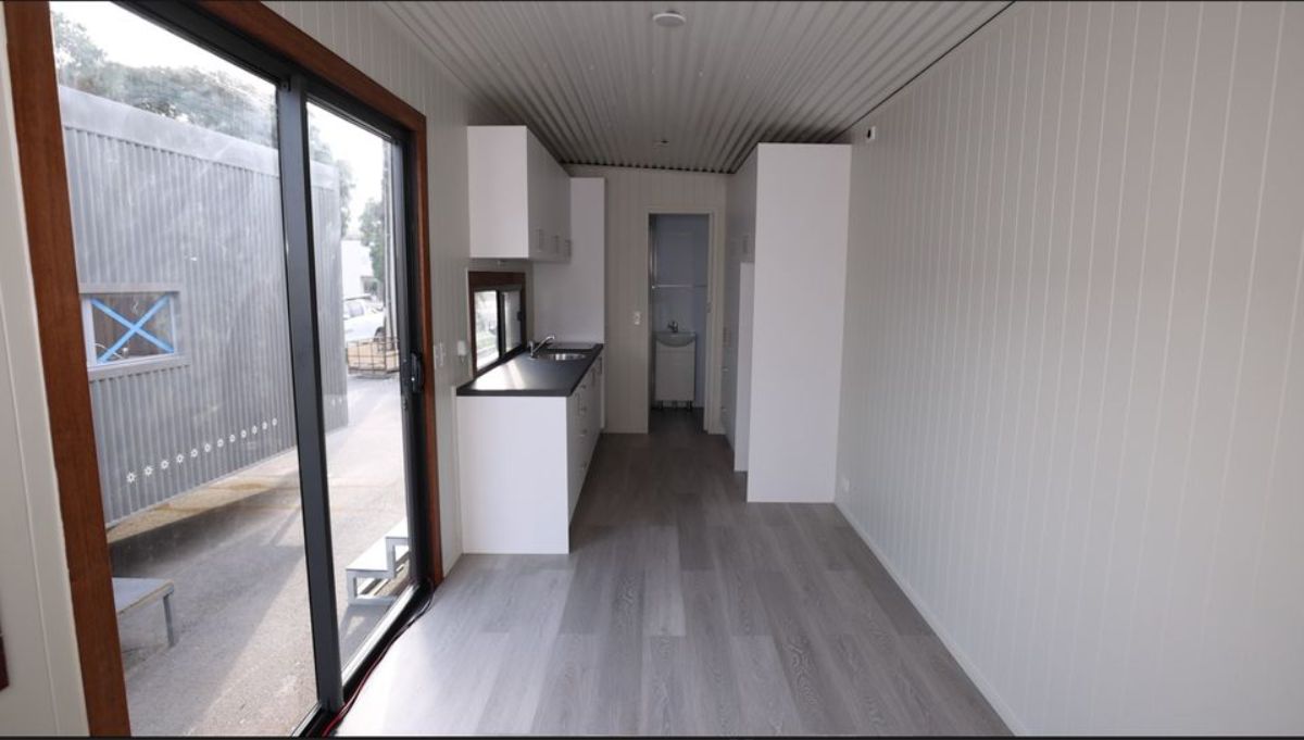 Dark gray flooring and glass door with glass windows of tiny shack house