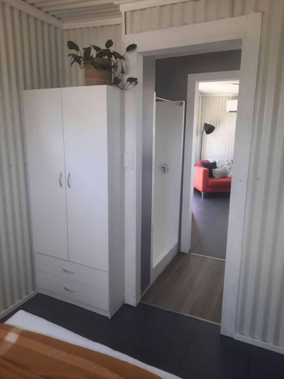 Wardrobe and shower area at the door of the bedroom