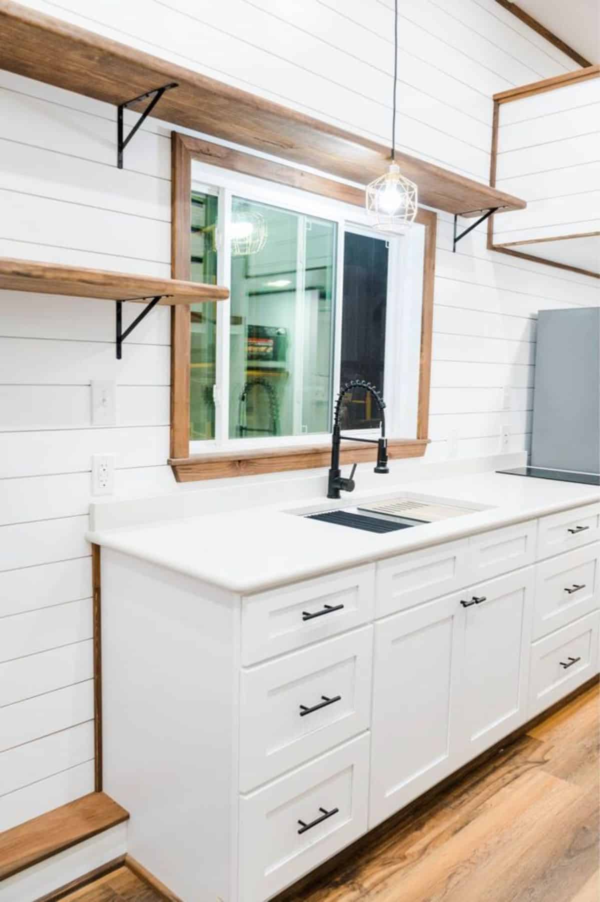 Stunning white themed kitchen area of 34’ custom built tiny home