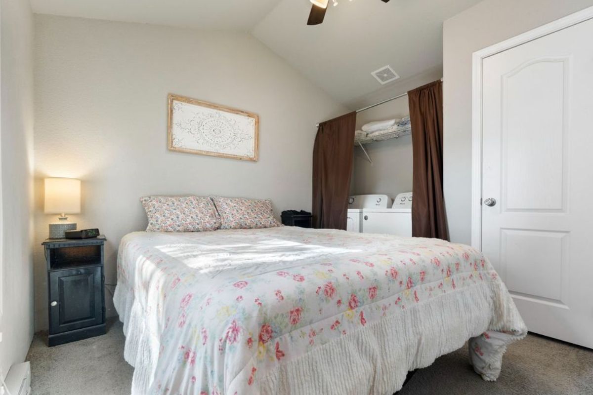 Bedroom of tiny home with a patio has a washer dryer