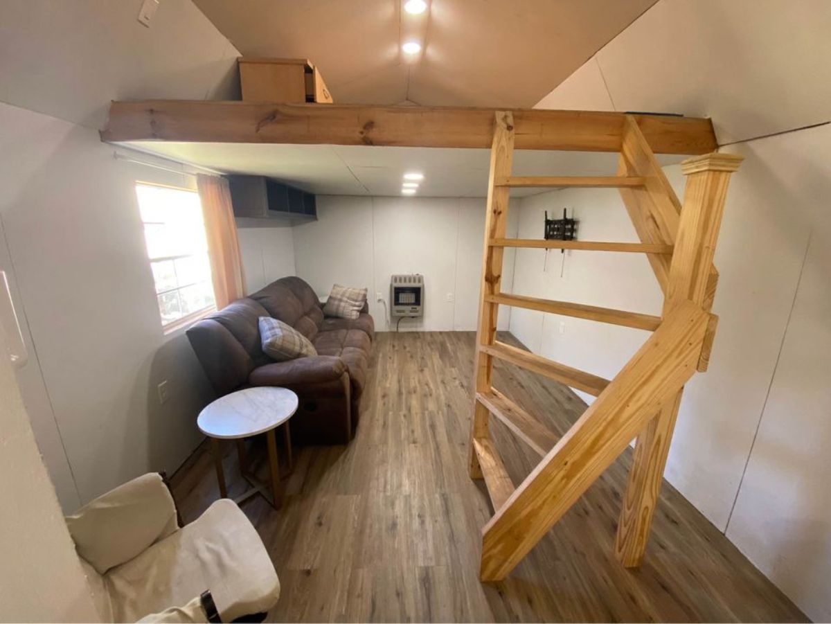 Living area, stairs leading to loft bedroom of 40’ shed converted tiny home