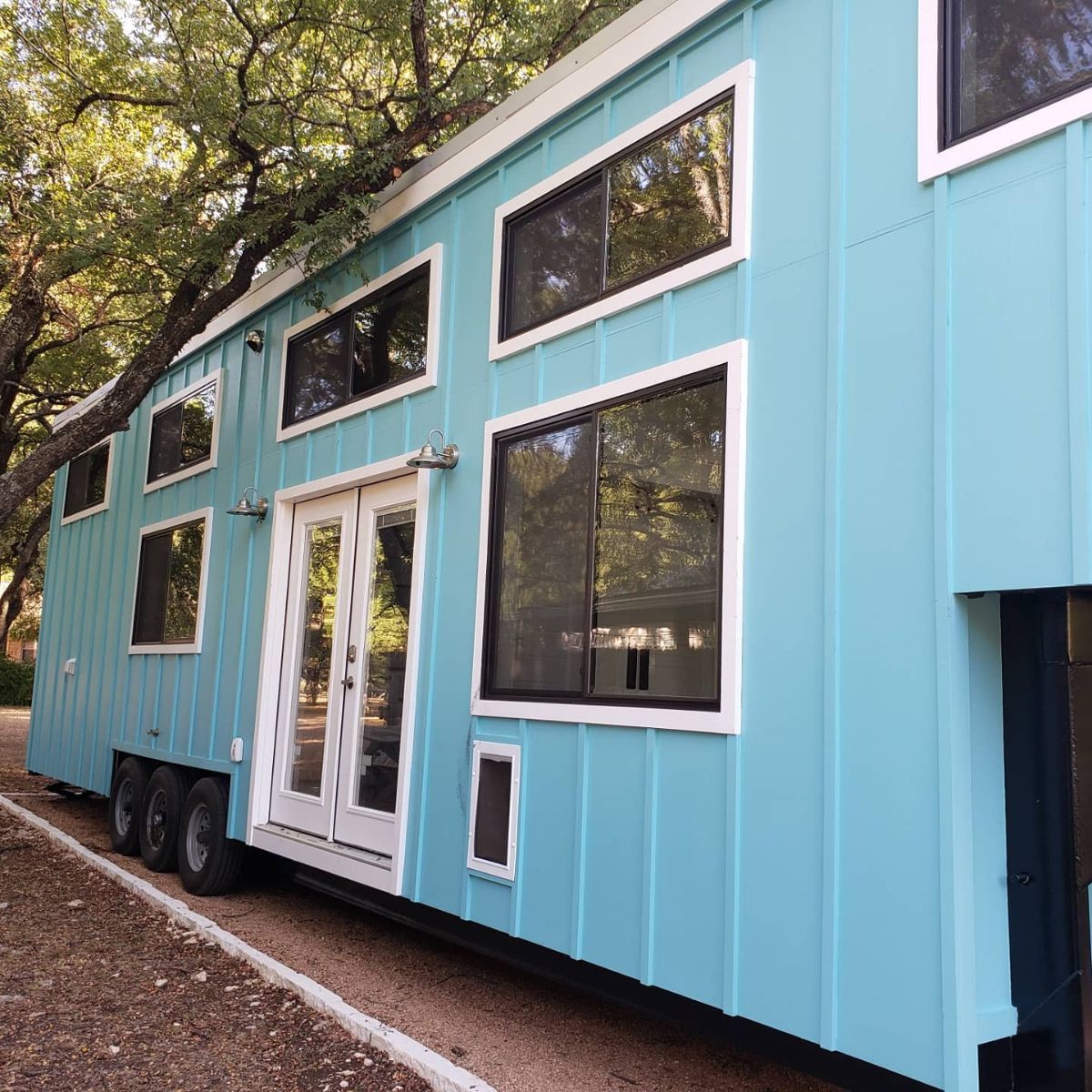 light teal tiny home with white trim