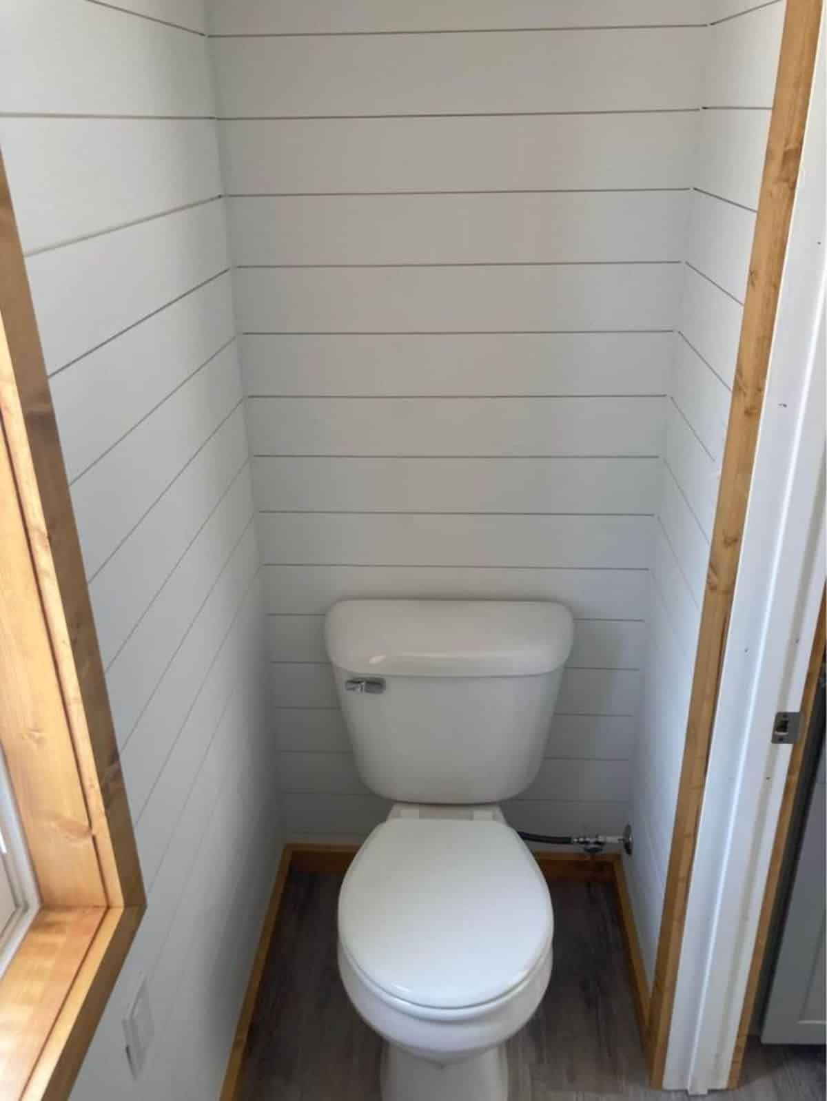 Standard toilet in bathroom of durable house on wheels