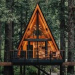 a-frame treehouse after dark with lights inside