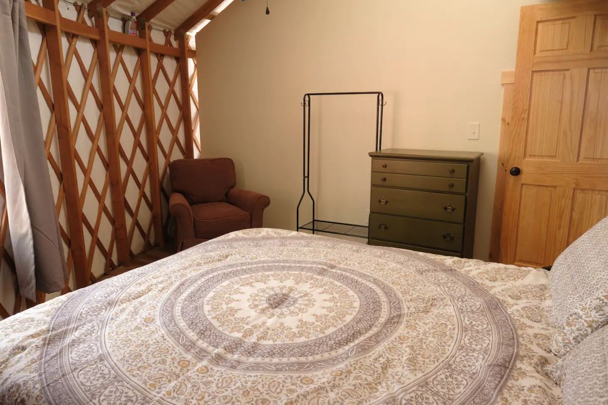 patterned bedding on bed in tiny home yurt bedroom