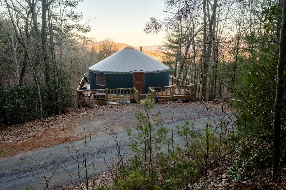 yurt with gravel drive in front and mountains in background