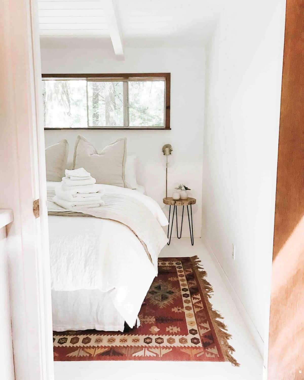 open door looking into bedroom with white duvet on bed